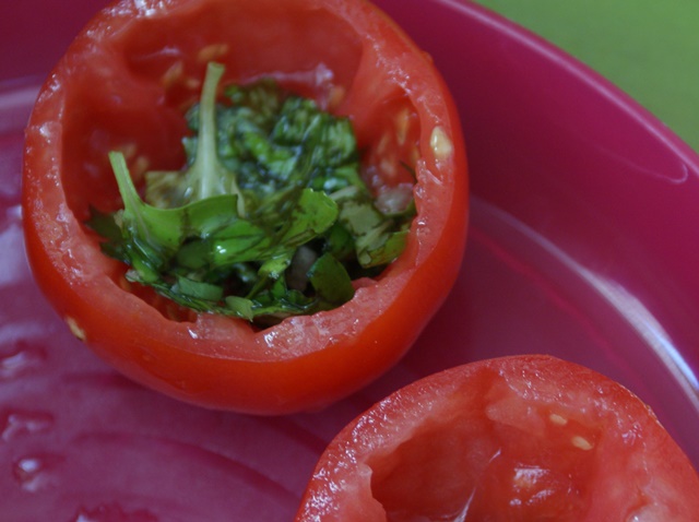 wydrążone pomidorki uzupełniamy bazylią z czosnkiem i olejem 